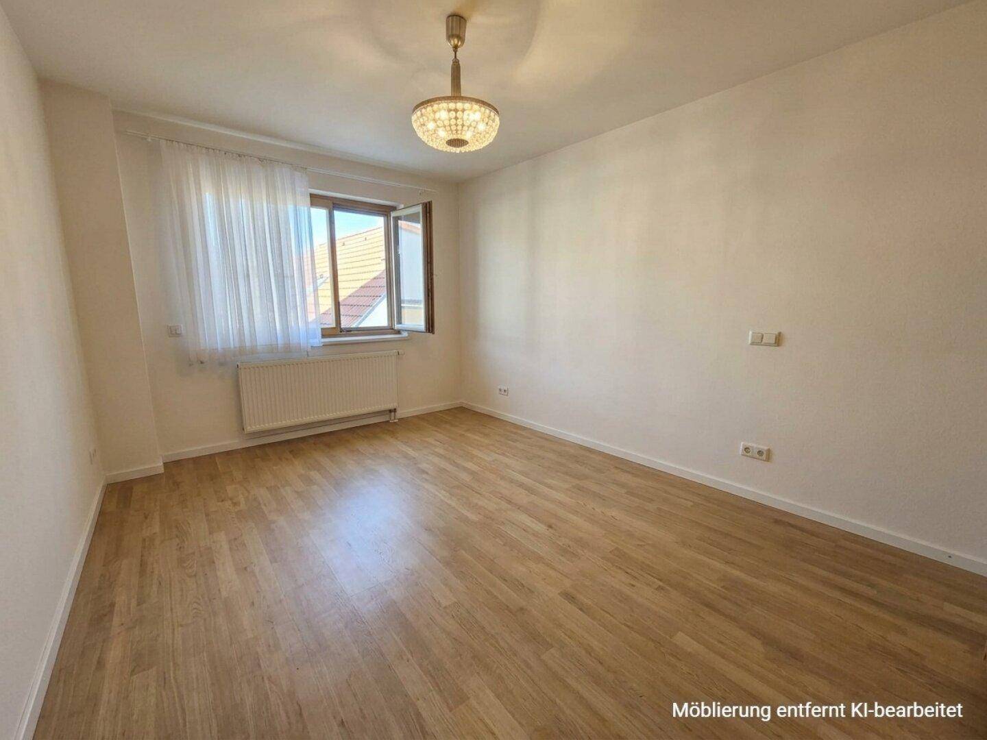 Lichtdurchflutetes Schlafzimmer mit Laminatboden und großem Fenster, bietet eine angenehme Atmosphäre.