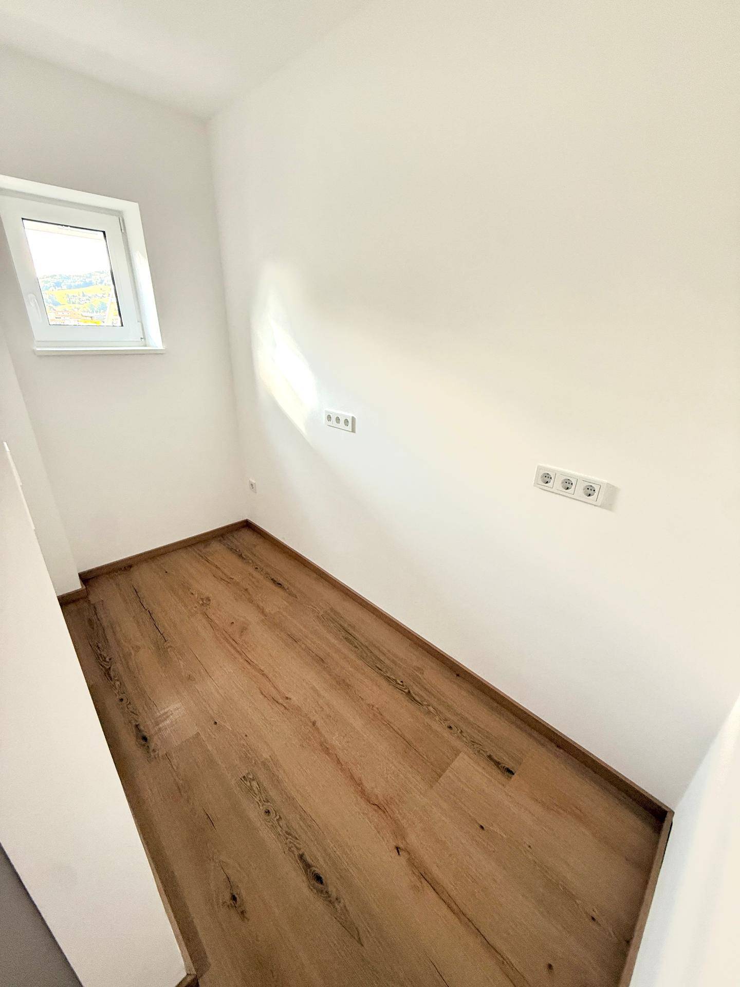Kleiner Raum mit Fenster und Laminatboden, ideal als Abstellraum oder Hauswirtschaftsraum nutzbar.