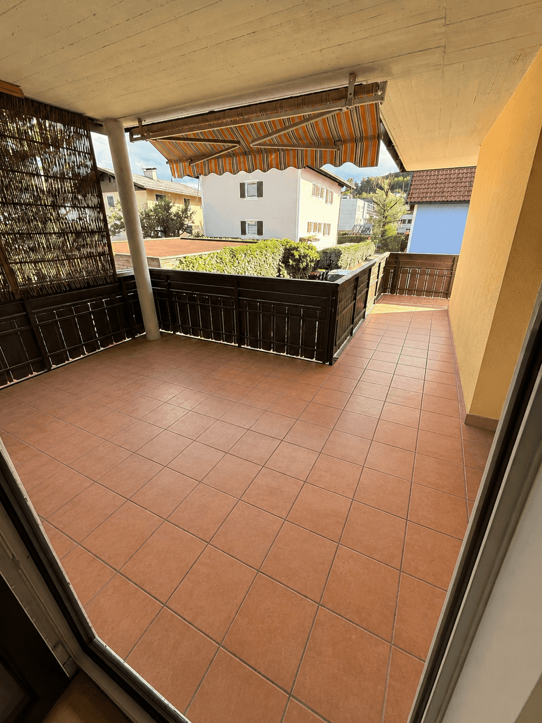 Geräumiger Balkon mit Fliesenboden und Markise, bietet Platz für Entspannung im Freien.