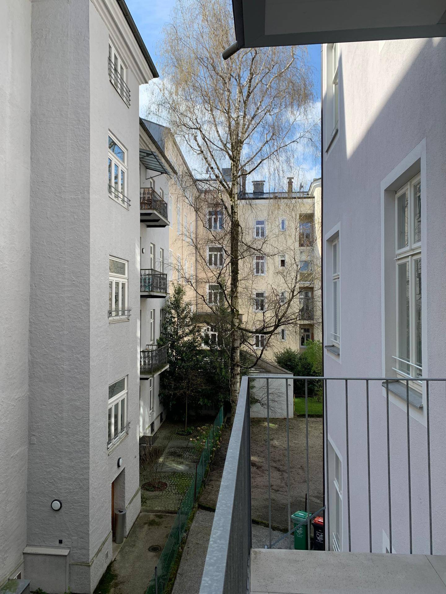 Balkon mit weitem Blick über den Innenhof und die umliegende Wohnbebauung.