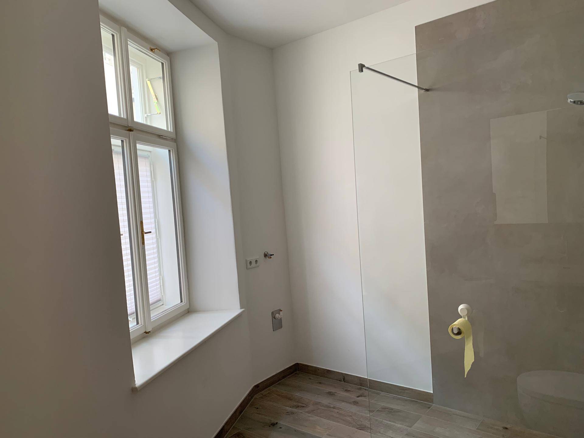 Helles Badezimmer mit Fenster, begehbarer Dusche und modernem Design.