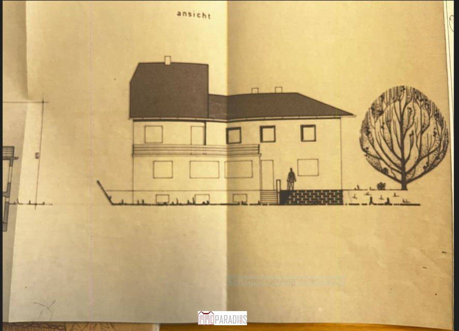 Seitenansicht des Gebäudes mit Fenstern und Eingangsbereich.