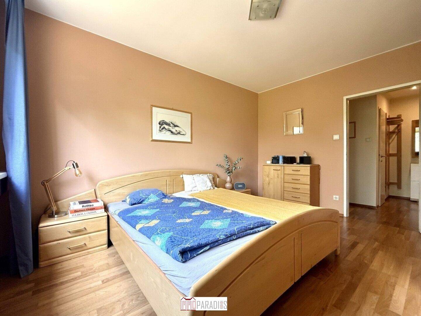 Gemütliches Schlafzimmer mit Holzbett, Nachttischen und Blick in den Flur.