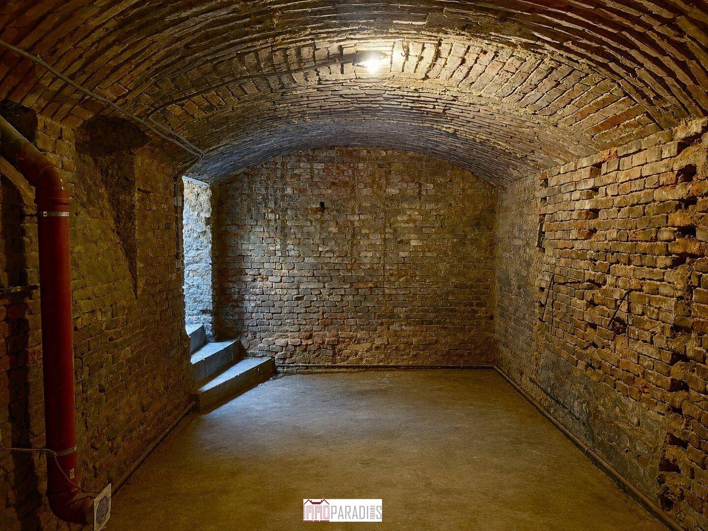Leerer Gewölbekeller mit freiliegenden Ziegelwänden und historischer Architektur.