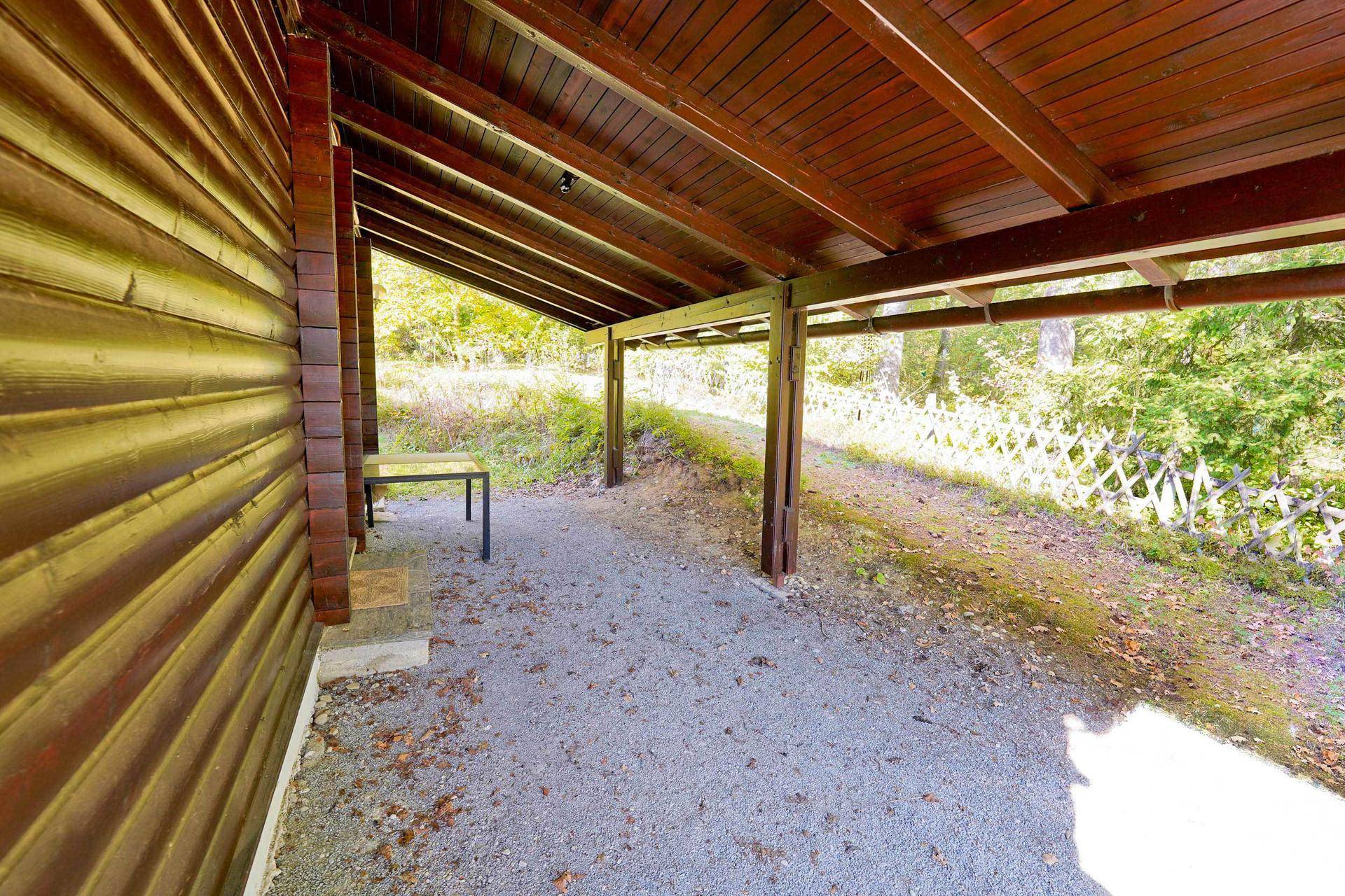 Überdachter Außenbereich mit Kiesboden, ideal als Carport oder geschützter Sitzplatz.
