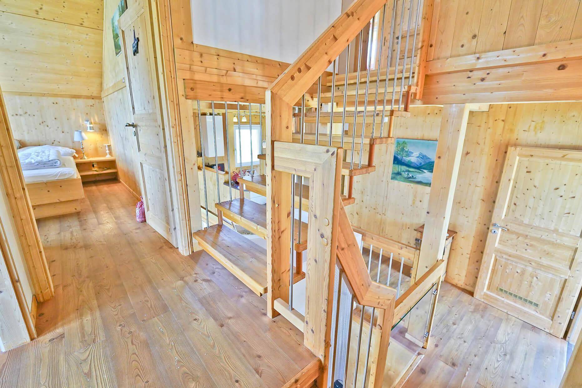 Heller Treppenabsatz mit Holztreppe und Zugang zu einem Schlafzimmer.