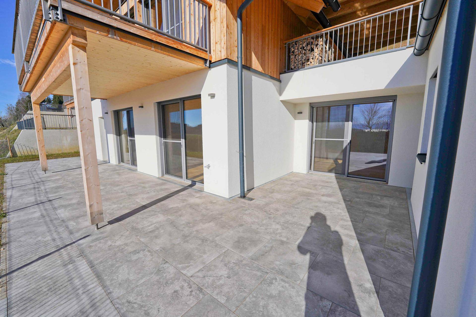 Große gepflasterte Terrasse mit Zugang zu den Innenräumen und Blick auf die Umgebung.