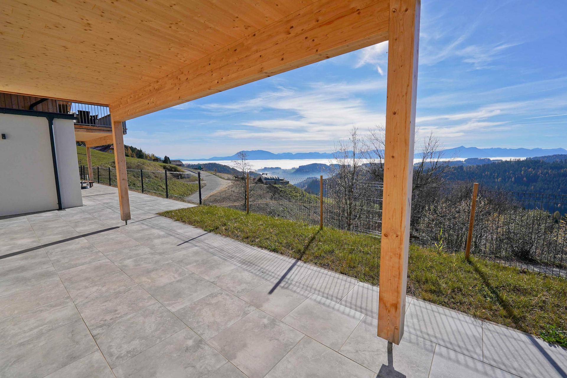 Überdachte Terrasse mit Holzbalken und weitem Blick über die malerische Landschaft.