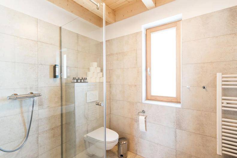 Modernes Badezimmer mit begehbarer Dusche, WC und Fenster.