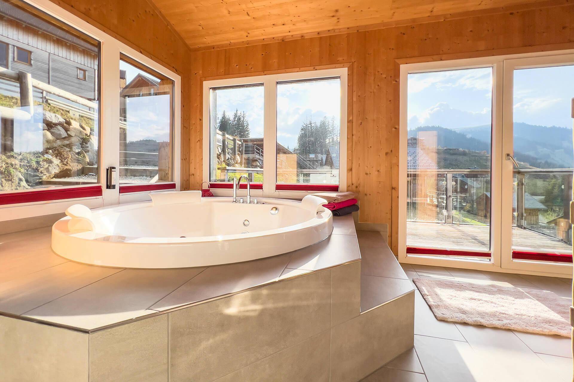 Whirlpool im Badezimmer mit Panoramablick auf die umliegende Berglandschaft.