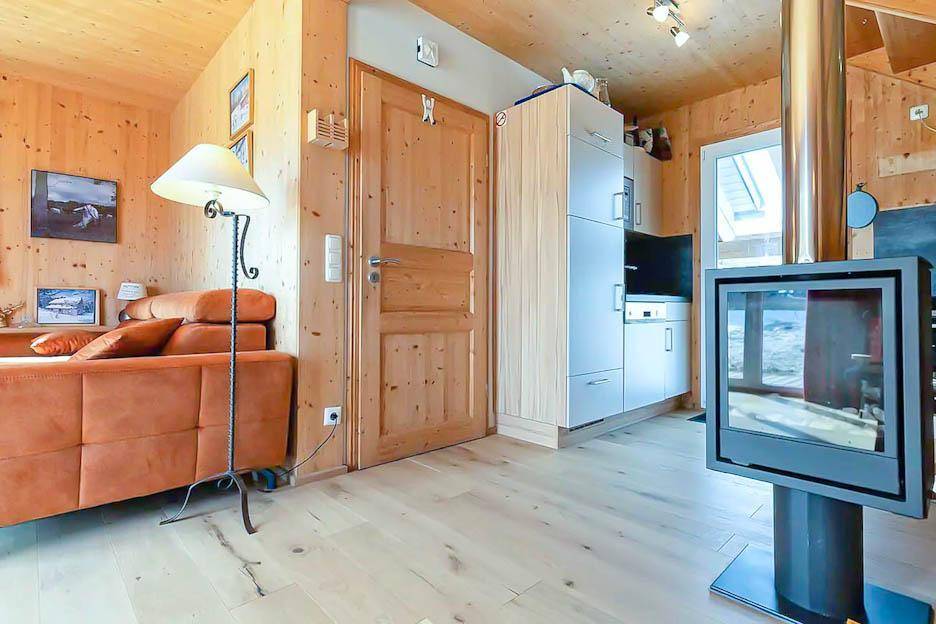 Wohnbereich mit bequemer Couch, modernem Kamin und Zugang zur Küchenzeile.