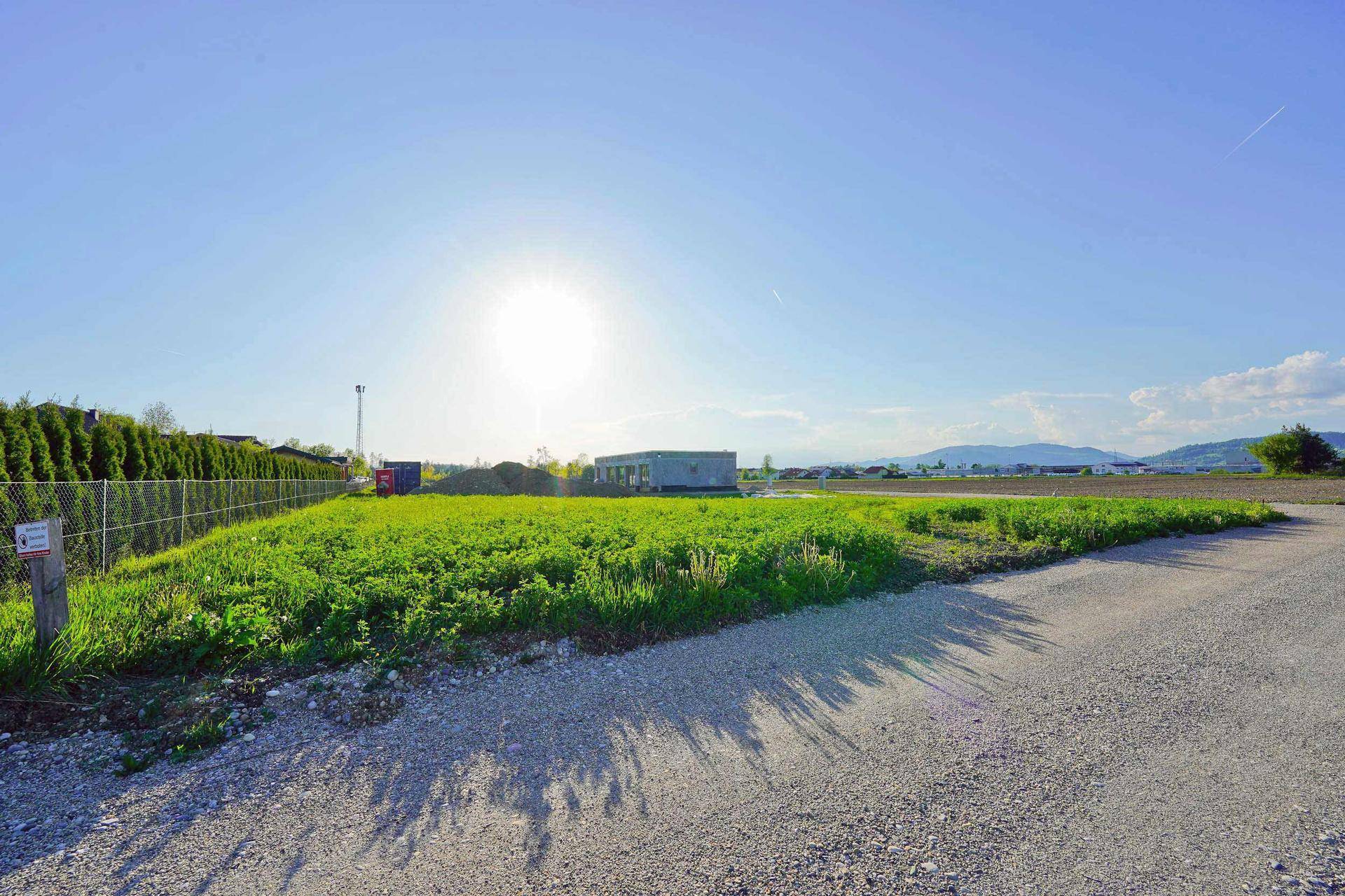 Sonniges Grundstück mit weitem Blick über grüne Flächen und angrenzende Bebauung.