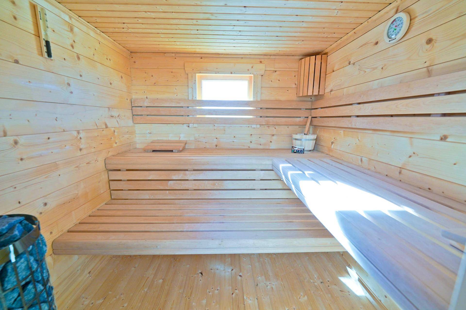 Gemütliche Holzsauna mit Bänken und kleinem Fenster für entspannende Momente.