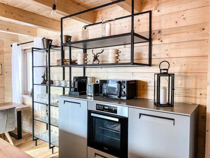 Gut ausgestattete Küche mit Backofen, Mikrowelle und Kaffeemaschine.