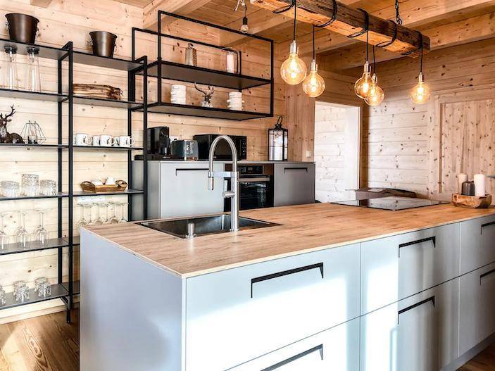Moderne Küche mit Holztheke, Spüle und offenen Regalen in rustikalem Ambiente.