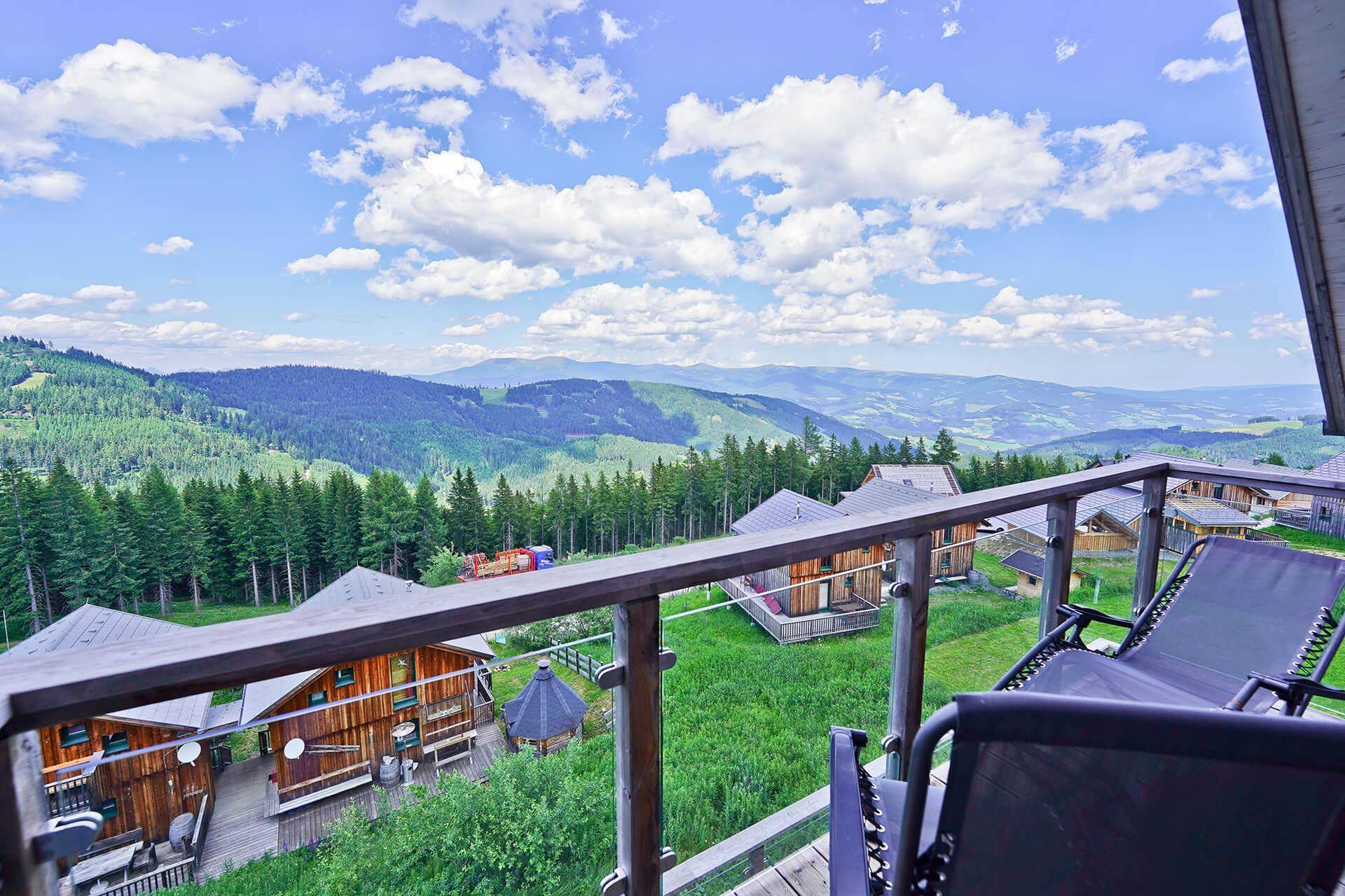 Balkon mit bequemen Liegestühlen und weitem Blick über die alpine Landschaft.