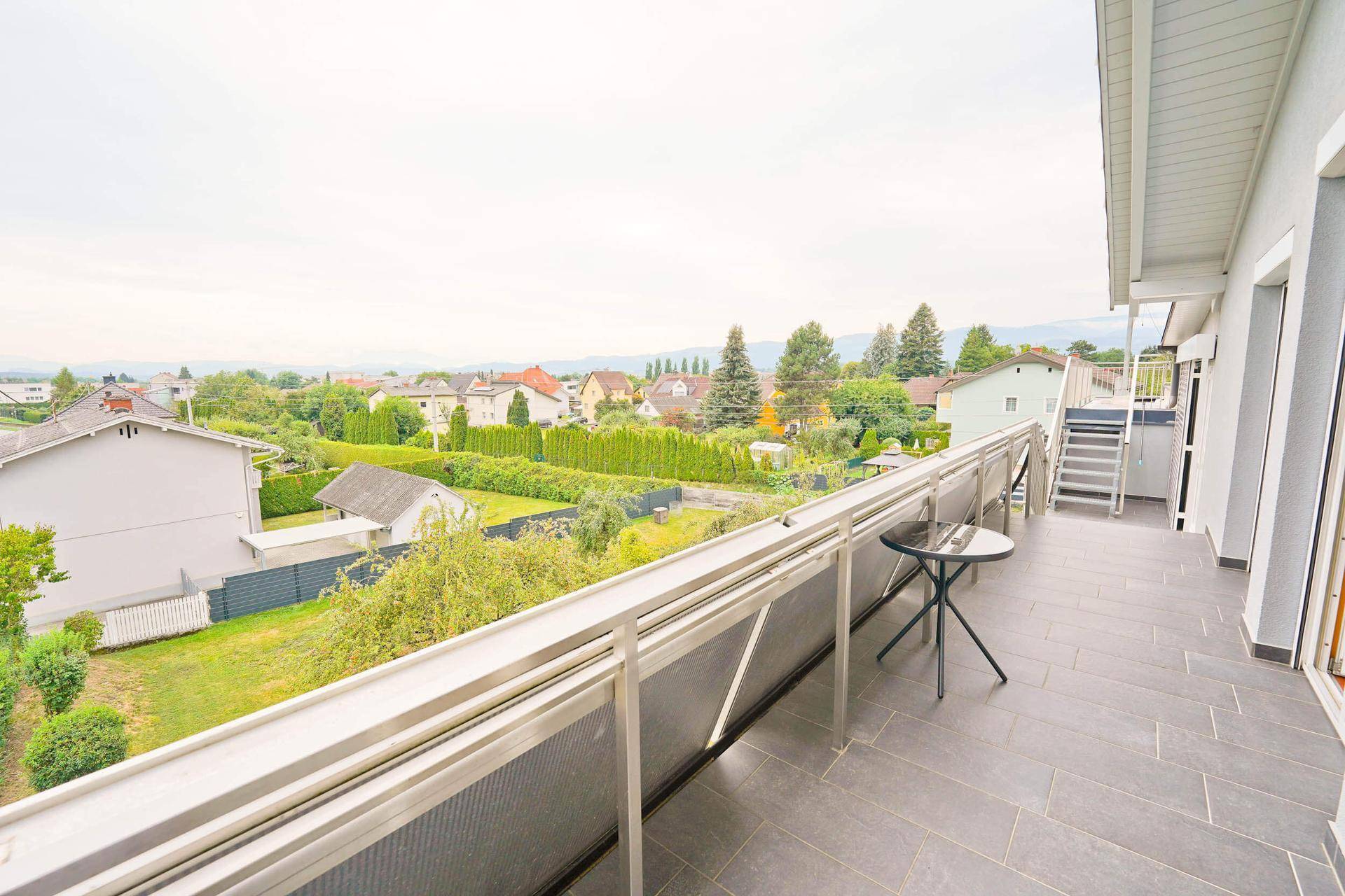 Großer Balkon mit Fliesenboden und weitem Blick über die umliegende Landschaft.