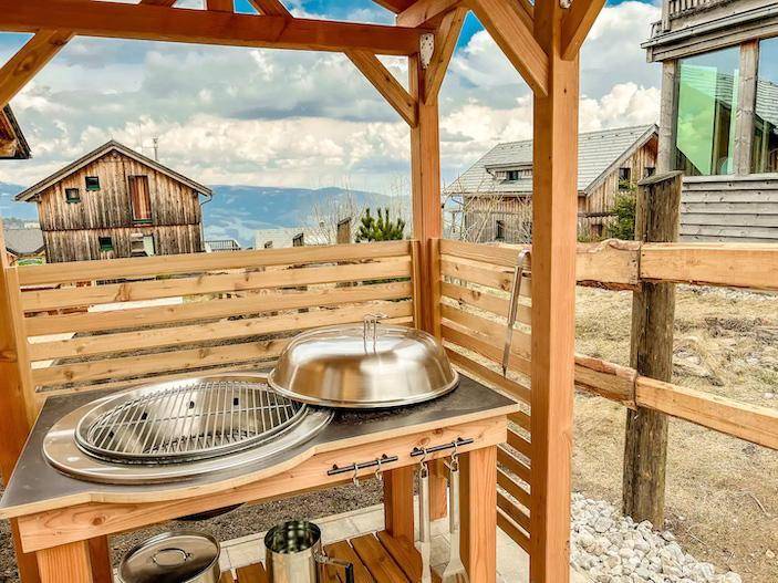 Überdachter Grillbereich mit moderner Grillstation und Bergblick.