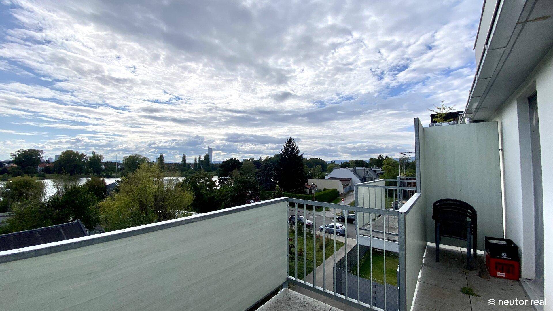 Geräumiger Balkon mit Sitzgelegenheiten und Panoramablick über den See und die Stadt.