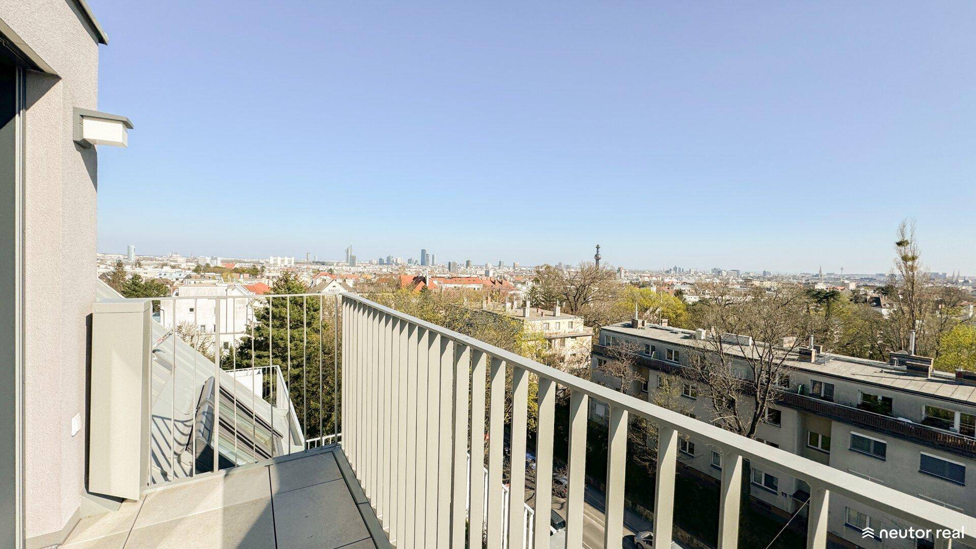 Balkon mit Metallgeländer und weitem Blick über die Stadt und ihre Skyline.