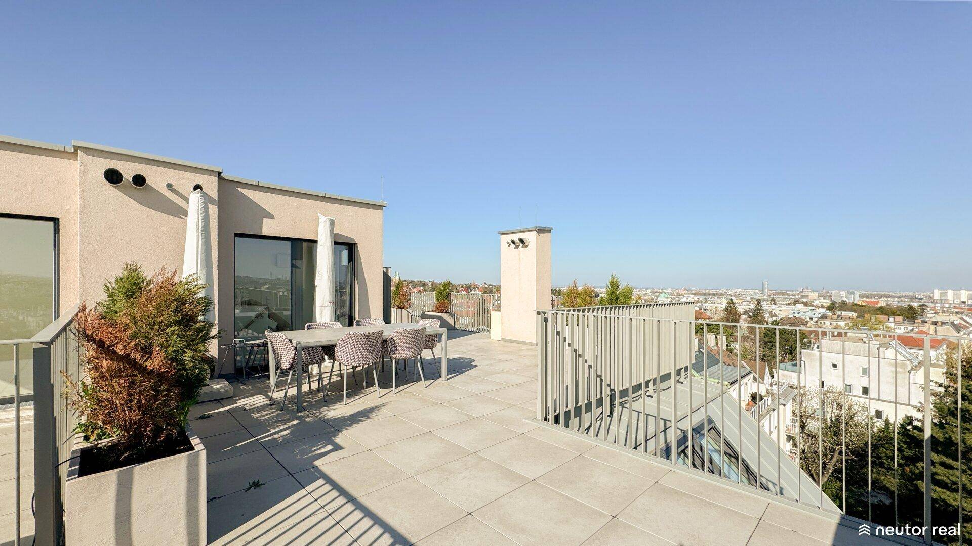 Geräumige Dachterrasse mit Sitzgelegenheiten und Pflanzen, die einen schönen Blick auf die Stadt bietet.
