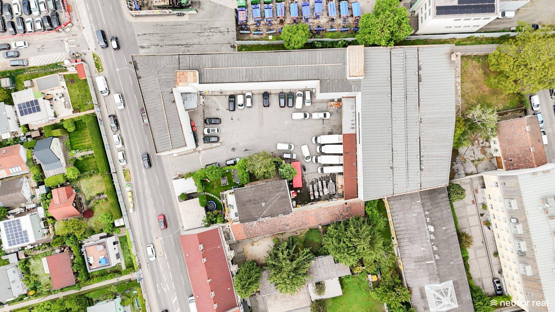Luftaufnahme des gesamten Gewerbegeländes mit Gebäuden, Parkplätzen und Zufahrtsstraßen.