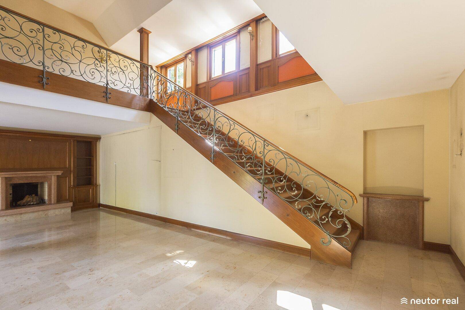 Geräumiger Eingangsbereich mit Marmorboden und eleganter Holztreppe.