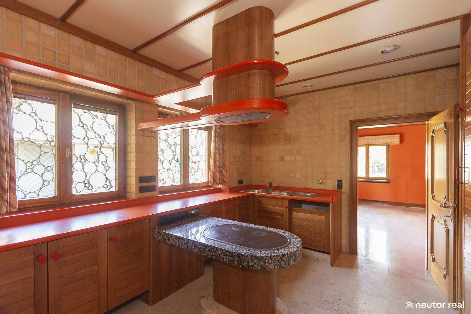 Küche im Retro-Stil mit orangefarbenen Arbeitsplatten und Holzelementen.