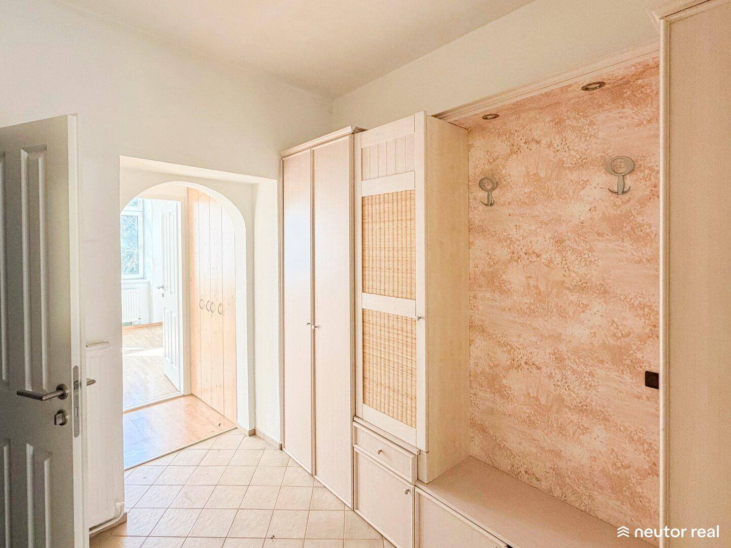 Heller Eingangsbereich mit Einbauschränken, Fliesenboden und Garderobe, in gutem Zustand.
