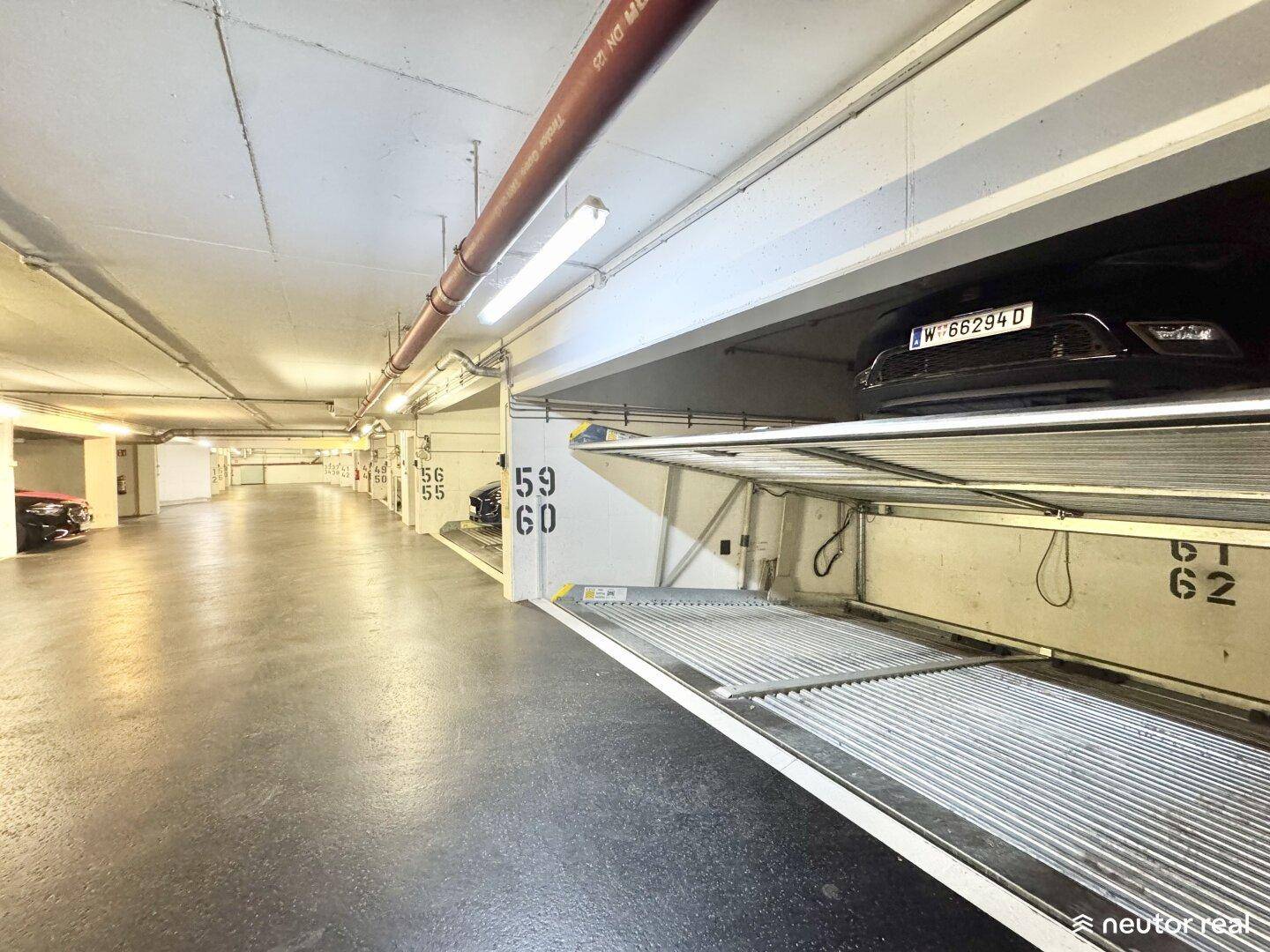 Lange Reihe von automatischen Parksystemen in einer Tiefgarage, einige davon belegt.
