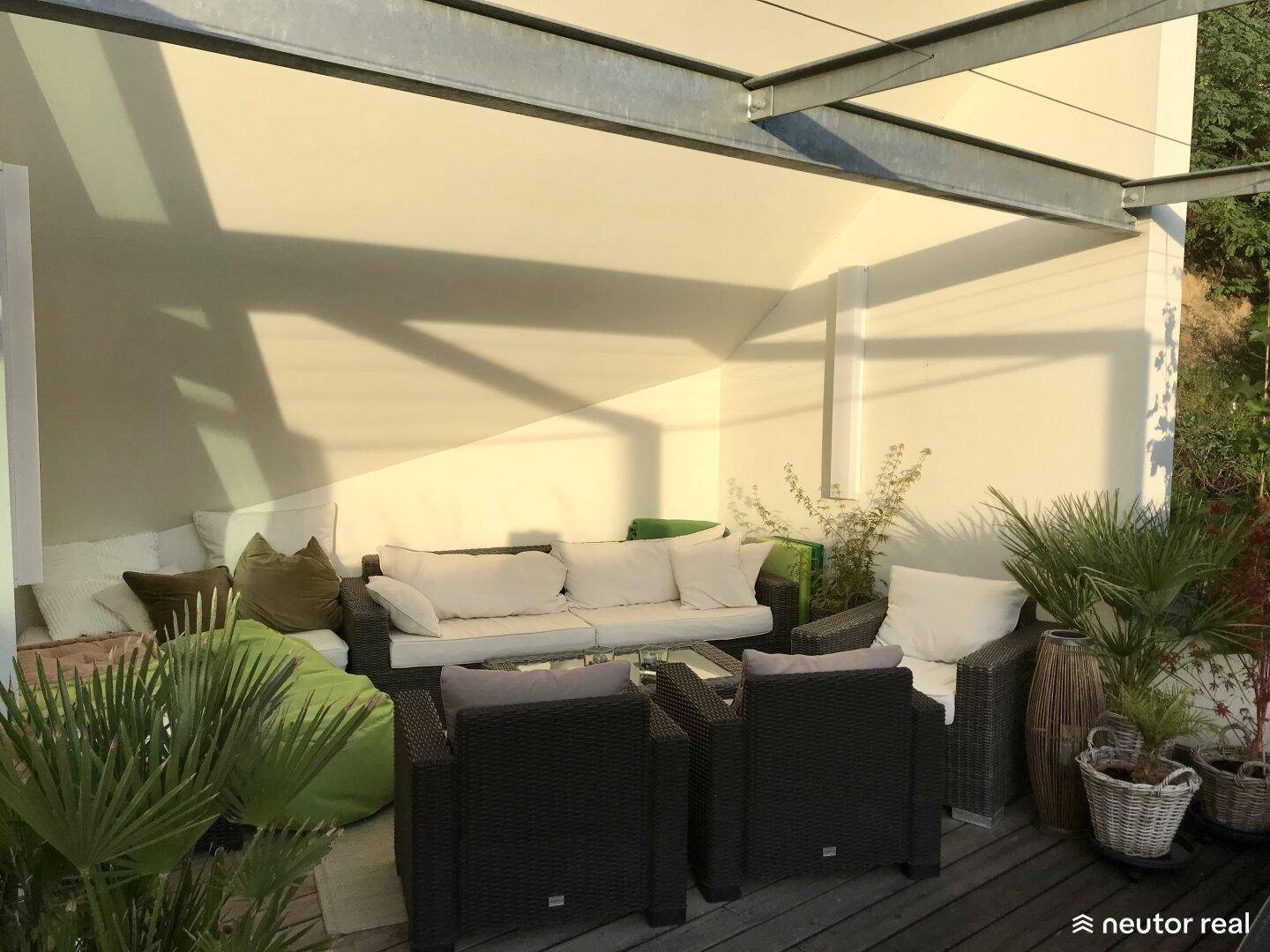 Überdachte Terrasse mit bequemen Loungemöbeln und Blick ins Grüne, ideal zum Entspannen.