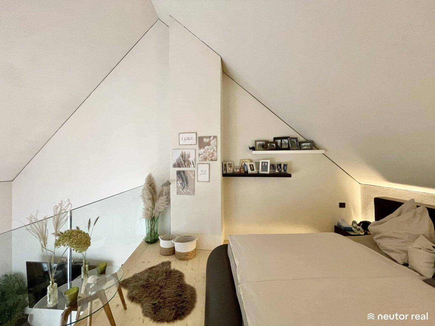 Helles Schlafzimmer auf der Galerie mit schrägen Wänden und minimalistischer Dekoration, bietet viel Ruhe.