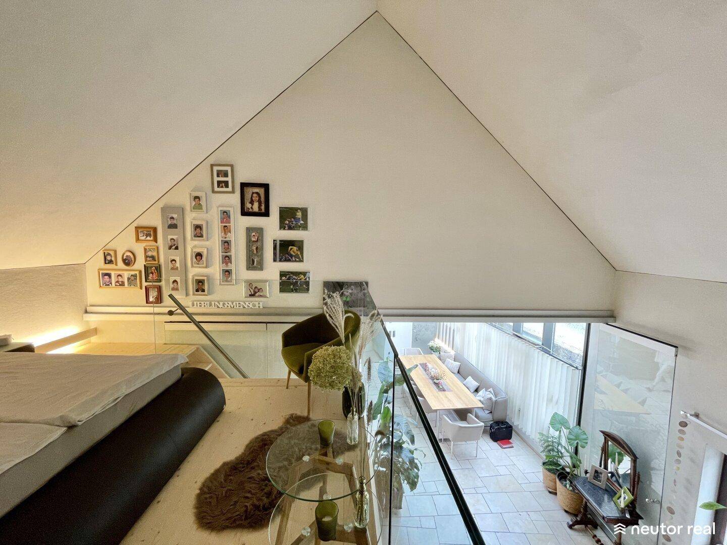 Blick vom Schlafzimmer auf der Galerie hinunter in den hellen Essbereich mit Glasfront.