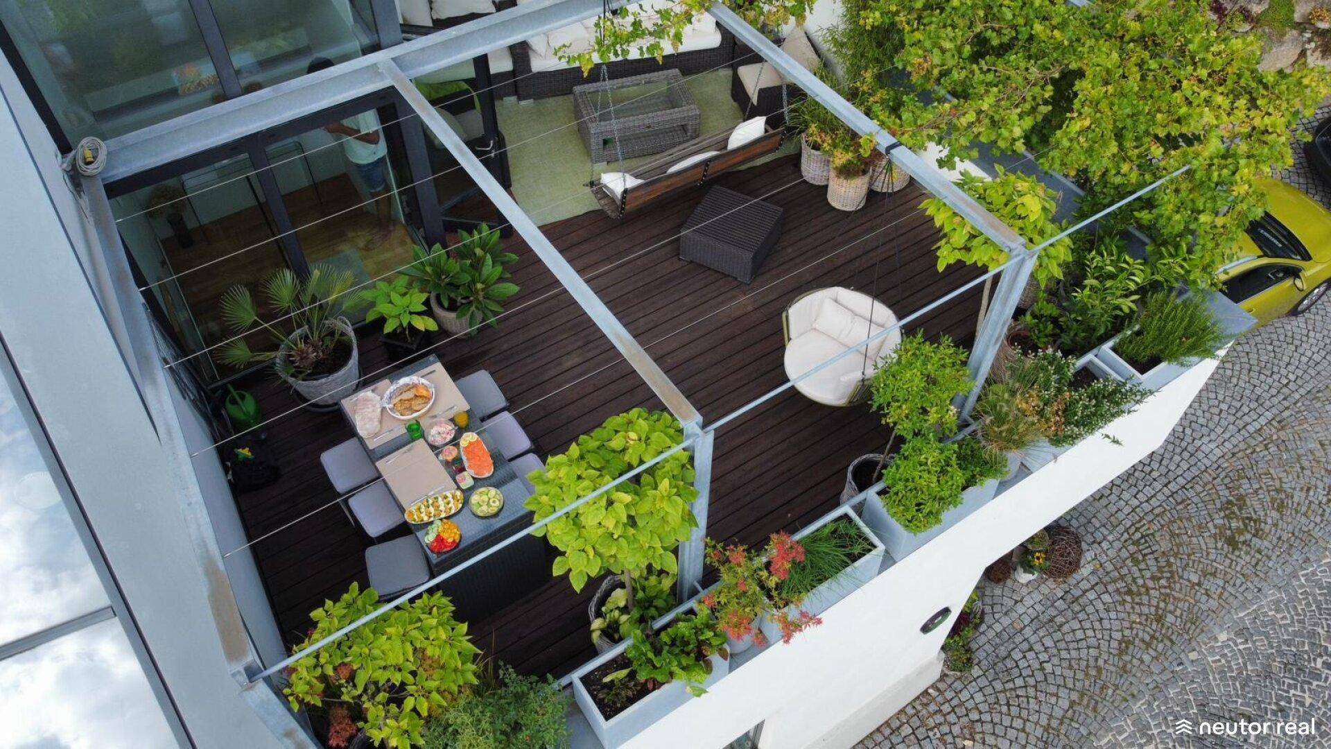 Geräumige Dachterrasse mit Esstisch, Sitzgelegenheiten und vielen Pflanzen, ideal zum Entspannen.