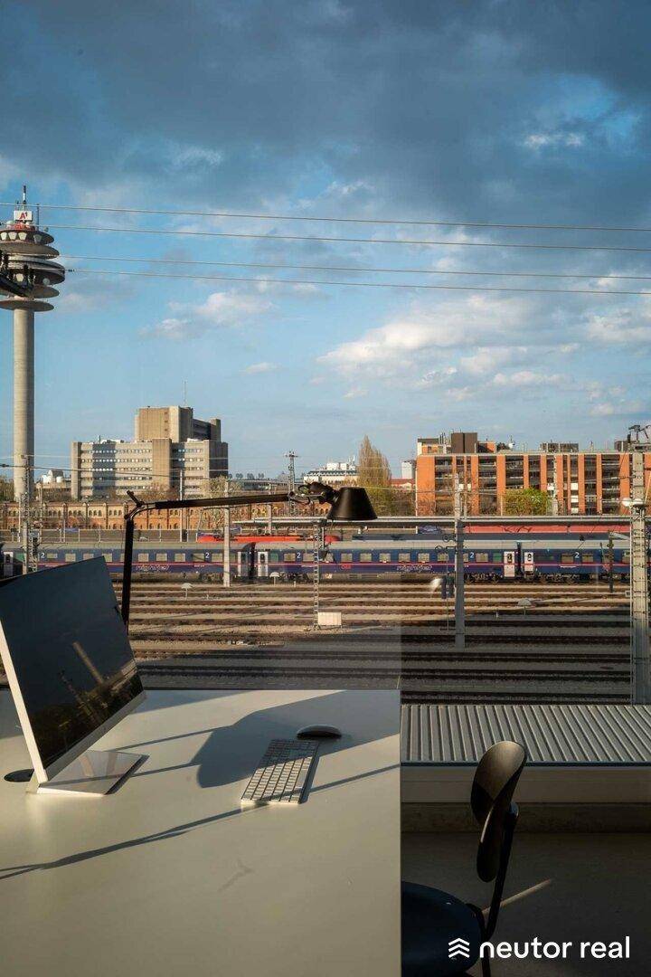Blick aus dem Bürofenster auf Bahngleise und die Stadtkulisse mit dem markanten Fernsehturm.
