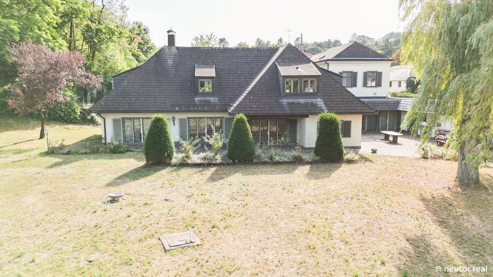Luftaufnahme des Anwesens mit großem Garten und umgebenden Bäumen.