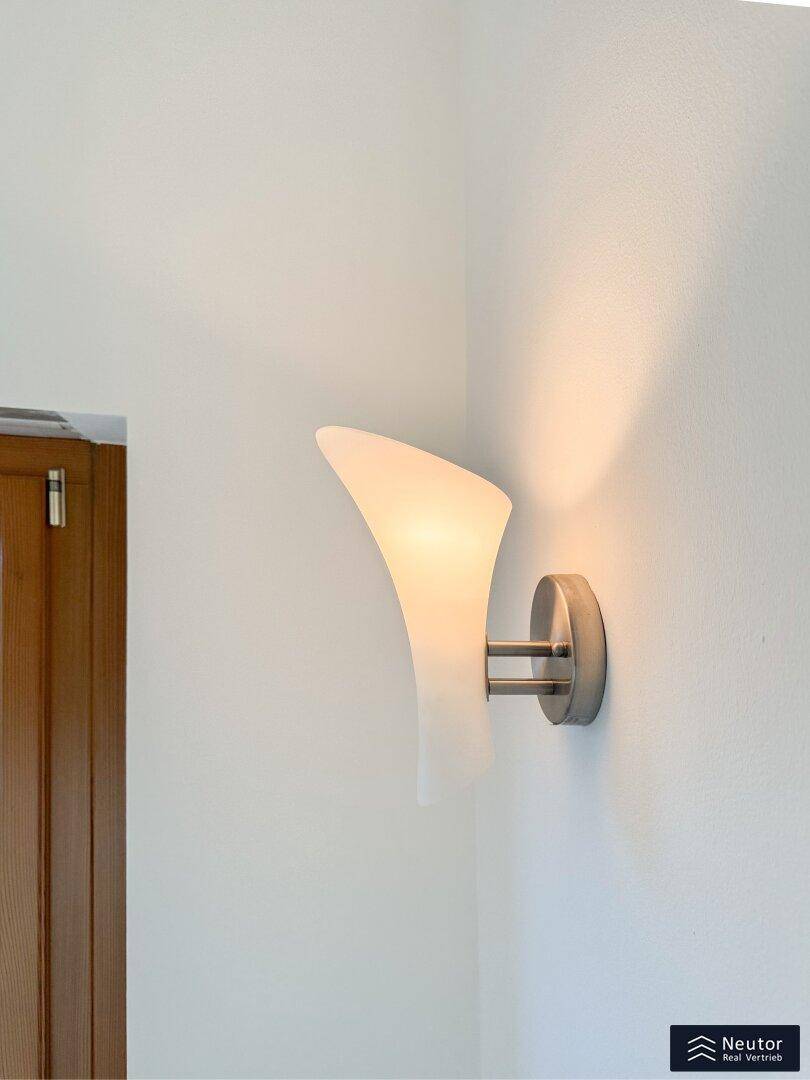Dekorative Wandleuchte mit sanftem Licht, die eine angenehme Atmosphäre schafft.