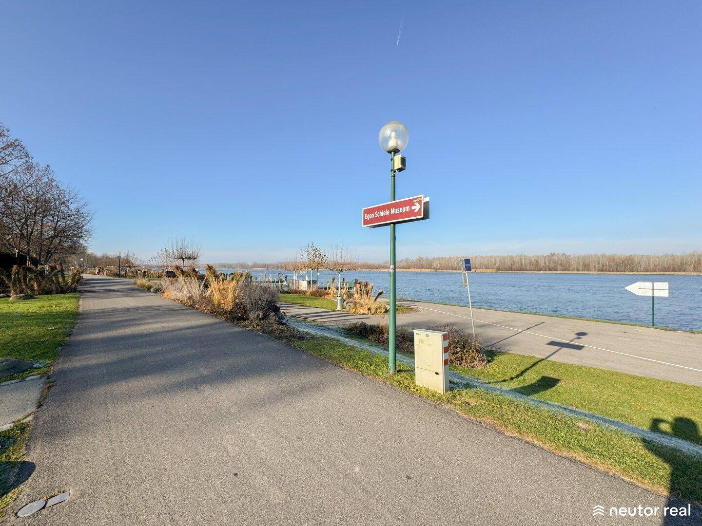 Uferpromenade mit Blick auf den Fluss und einen Weg.