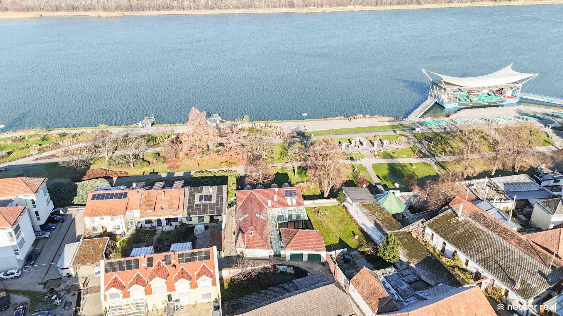 Luftaufnahme der Wohngegend am Fluss mit Häusern und Grünflächen.