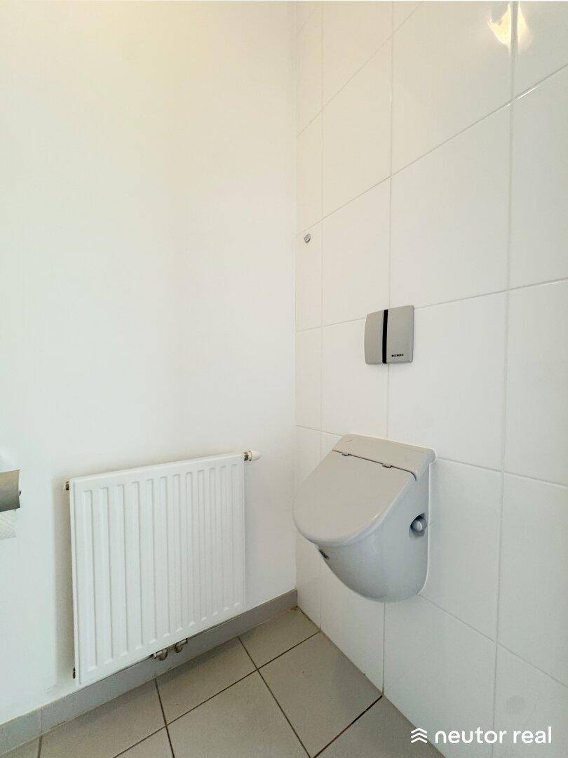 Sauberes Gäste-WC mit wandhängender Toilette und Heizkörper, in schlichtem Design gehalten.