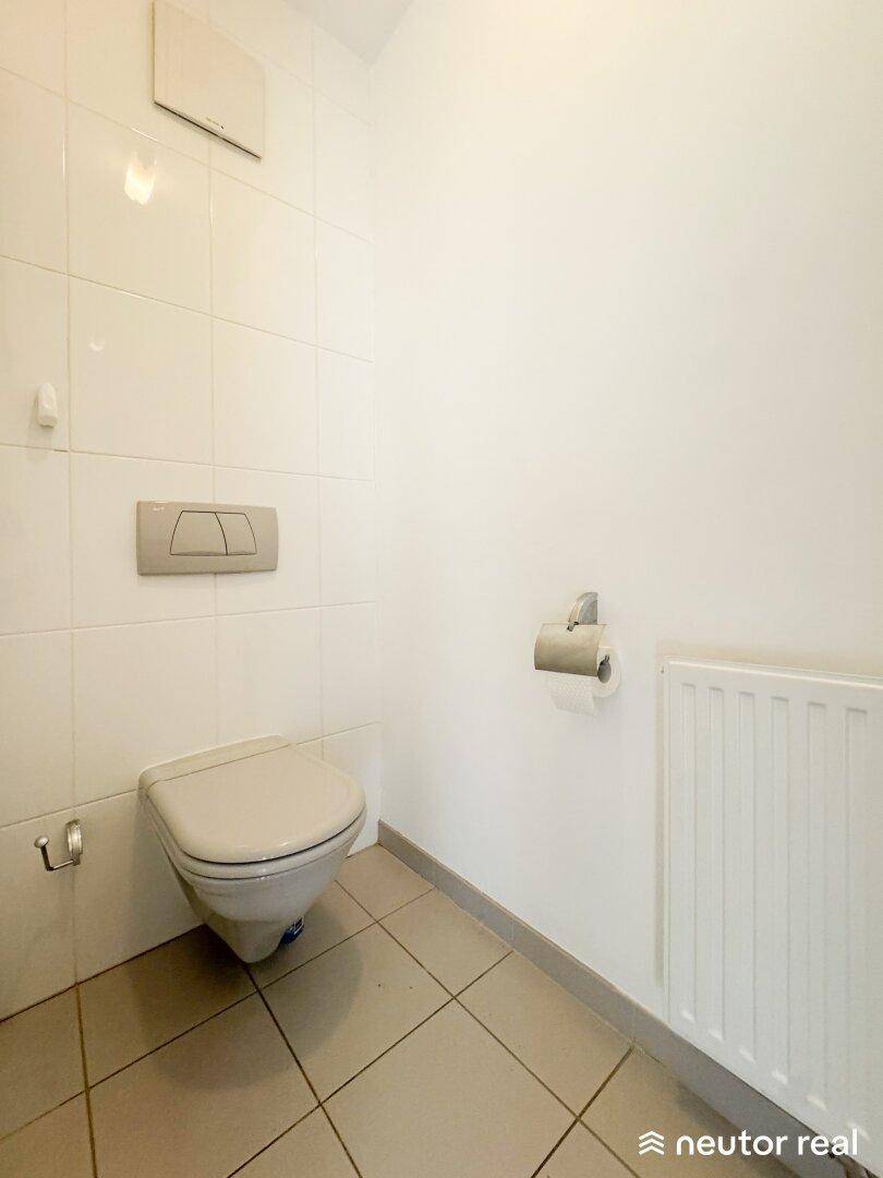 Kleines Gäste-WC mit Wand-WC und Fliesenboden.