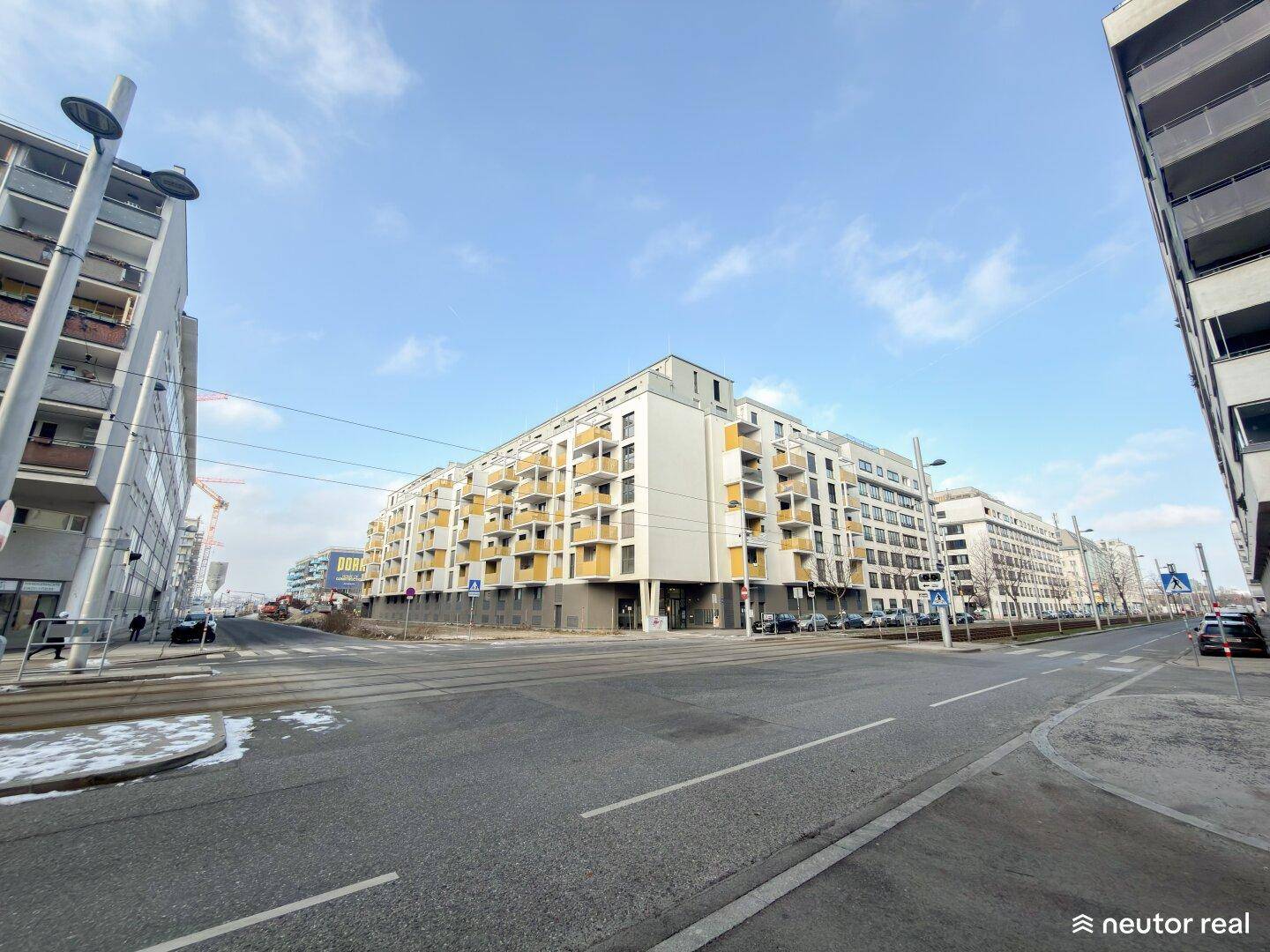Moderne Wohnanlage mit zahlreichen Balkonen und zeitgenössischer Architektur an einer Straße.