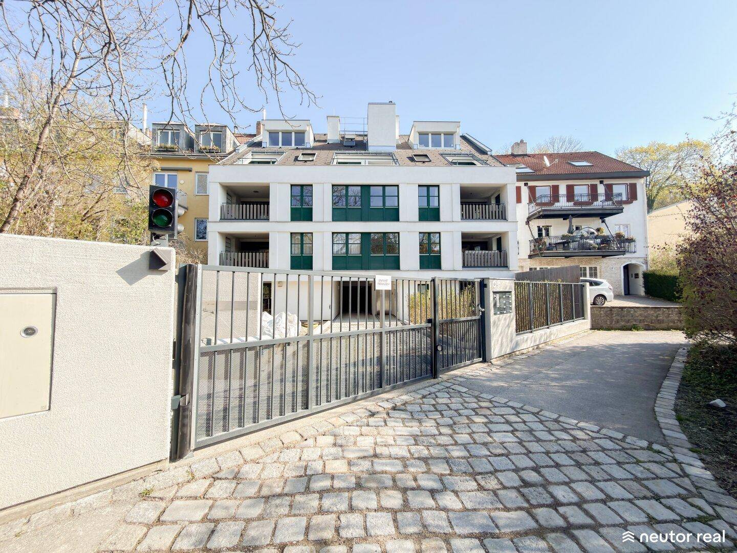 Moderne Wohnanlage mit weißer Fassade, grünen Akzenten und Balkonen.