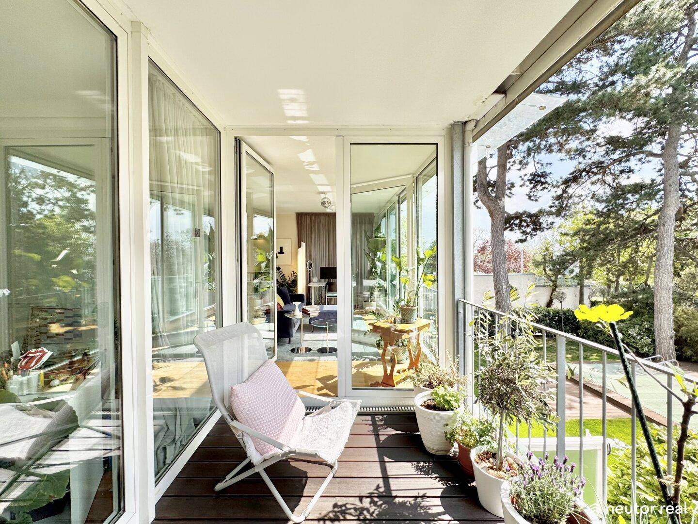 Sonniger Balkon mit Pflanzen und Blick auf den Garten, direkt vom Wohnbereich zugänglich.