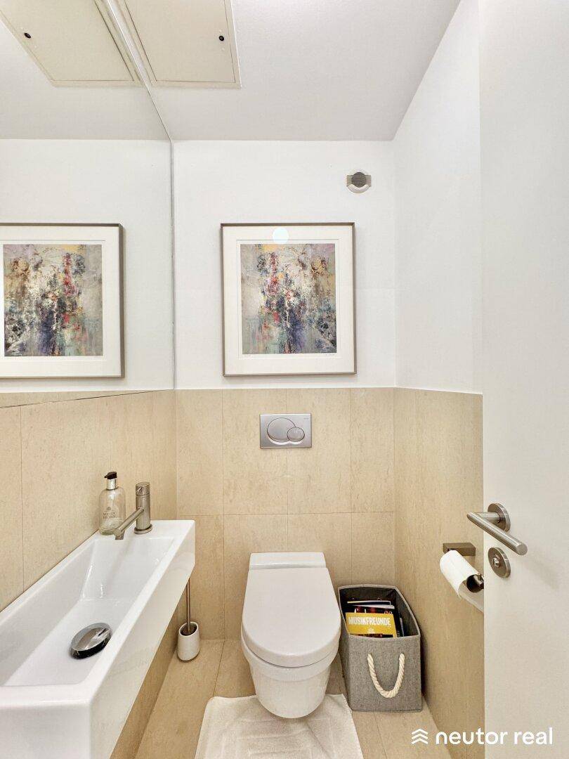 Modernes Gäste-WC mit wandhängender Toilette und kleinem Waschbecken.