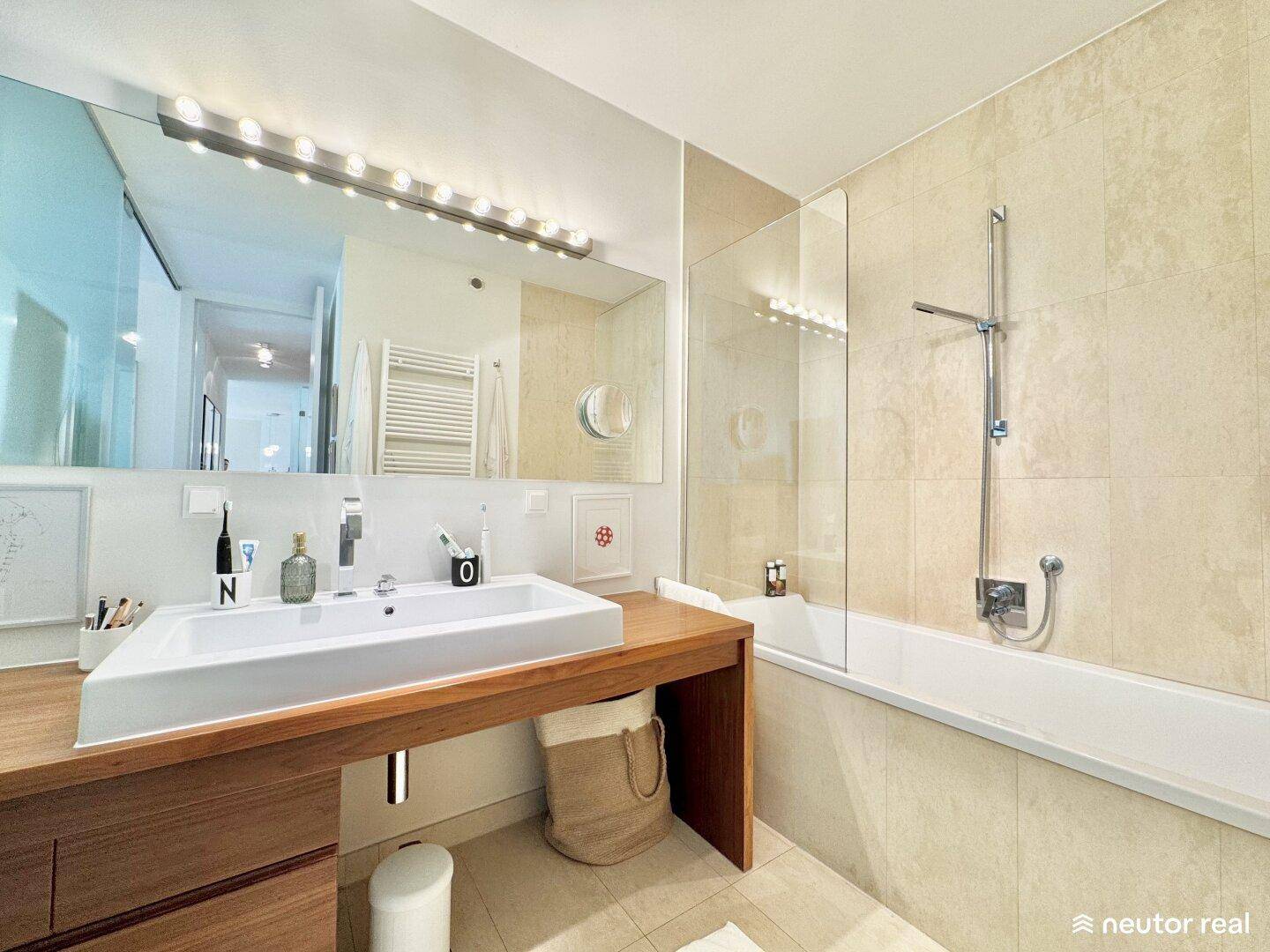 Modernes Badezimmer mit Badewanne, großem Waschbecken und beheiztem Handtuchhalter.