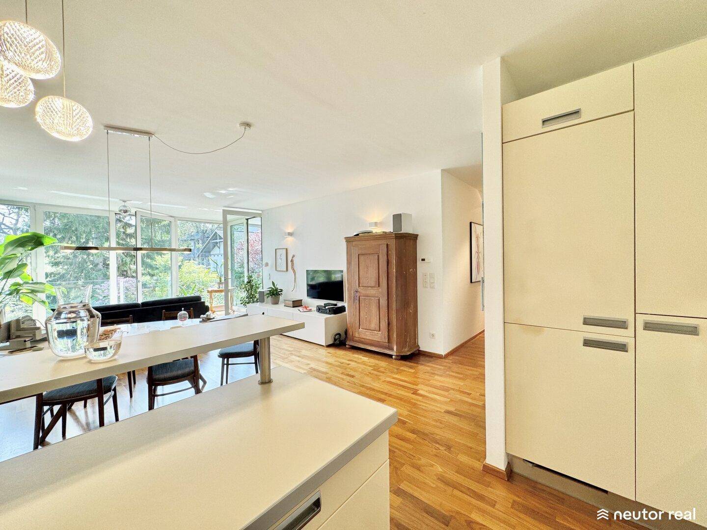 Offene Küche mit integriertem Kühlschrank und Blick auf den Wohn- und Essbereich.