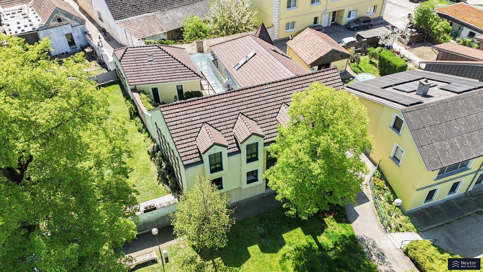 Luftaufnahme des Anwesens mit Garten und umliegenden Häusern, zeigt die Gesamtstruktur.