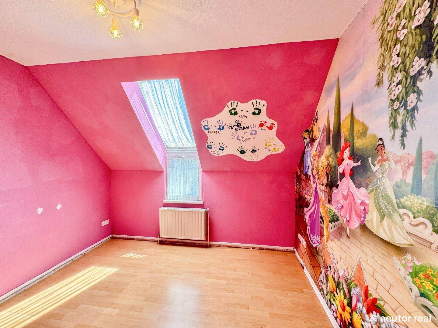 Kinderzimmer mit Holzparkett, Dachfenster und farbenfroher Wandmalerei mit Prinzessinnenmotiv.
