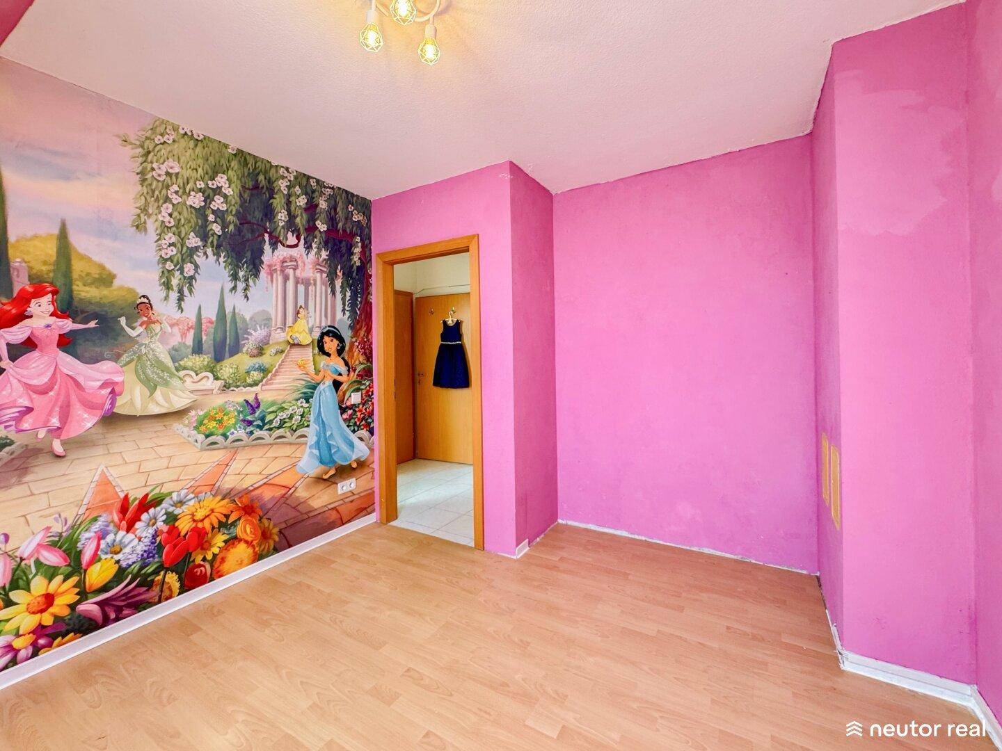 Helles Kinderzimmer mit lebhaftem Prinzessinnen-Wandbild und rosa gestrichenen Wänden.